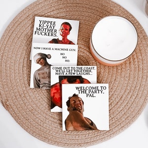 May include: Three stickers featuring characters from the film 'Die Hard'. The first sticker features the character John McClane with the text 'Yippee Ki-Yay Mother Fuckers'. The second sticker features the character John McClane with the text 'Now I have a machine gun. Ho Ho Ho'. The third sticker features the character John McClane with the text 'Come out to the coast, we'll get together, have a few laughs... Welcome to the party, pal.'