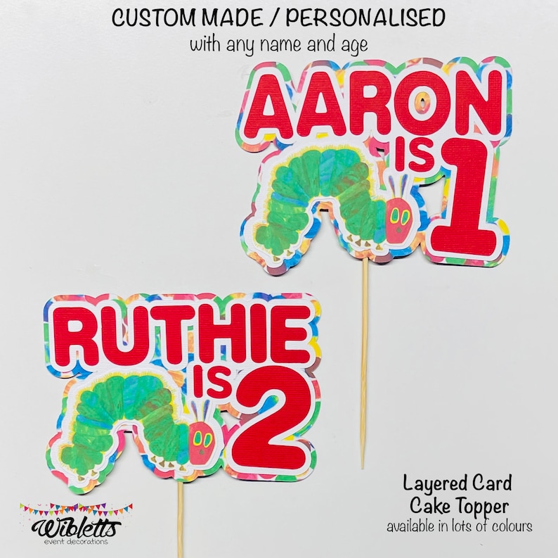 May include: Two colorful layered card cake toppers featuring the Very Hungry Caterpillar. The first topper says "AARON is 1" and the second topper says "RUTHIE is 2".