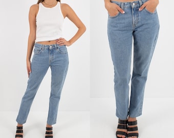May include: A pair of light blue denim jeans with a straight leg fit. The jeans have a classic five-pocket style and a button fly.