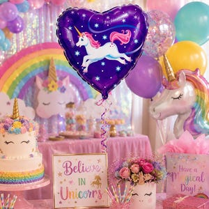 May include: A heart-shaped purple foil balloon featuring a white unicorn with a pink mane and tail, surrounded by white stars. The balloon is part of a party display with a unicorn cake, a sign that says Believe IN Unicorns, and flowers.