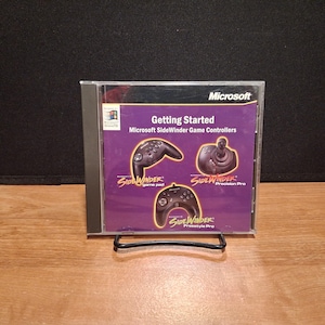 May include: A clear plastic CD jewel case containing a Getting Started manual for Microsoft SideWinder game controllers. The cover features a purple background with images of the SideWinder game pad, Precision Pro, and Freestyle Pro controllers.