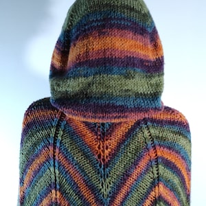 May include: A hooded poncho knitted in a colourful striped pattern with shades of green, orange, purple, and blue.