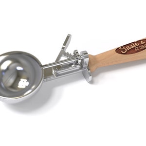 May include: A silver ice cream scoop with a wooden handle. The handle has a brown woodgrain finish and the text "Susie's Ice Cream" is engraved on it.
