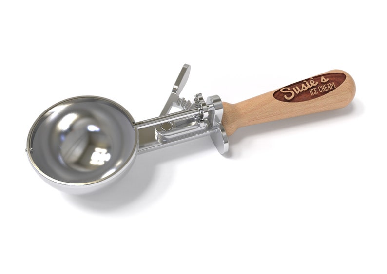 May include: A silver ice cream scoop with a wooden handle. The handle has a brown woodgrain finish and the text "Susie's Ice Cream" is engraved on it.