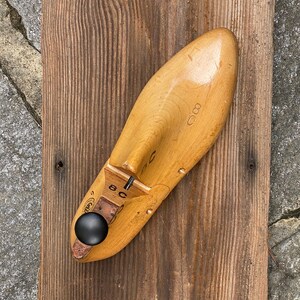 May include: A wooden shoe last with a black knob. The last is marked with the number "8C" and "688".