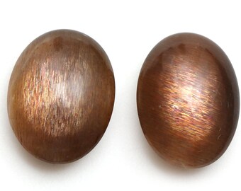 May include: A pair of round, brown sunstone earrings with a shimmery, iridescent finish.