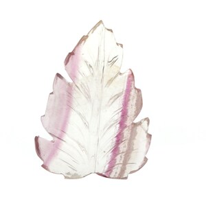 May include: A carved leaf pendant made of clear fluorite with pink and purple striations.