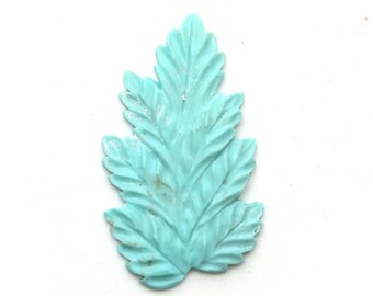 May include: A light blue leaf-shaped decorative accent with a detailed design.