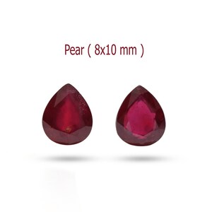 May include: Two pear-shaped red gemstones, each measuring 8x10 mm. The gemstones are faceted and have a deep red color.