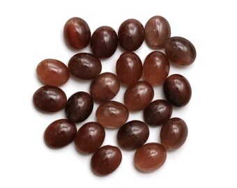 May include: A collection of 20 oval-shaped, brown gemstone cabochons. The stones have a smooth, polished surface and a translucent appearance.