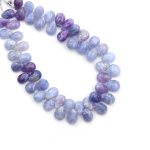 May include: A strand of blue and purple gemstone beads in a teardrop shape. The beads are strung on a silver wire.