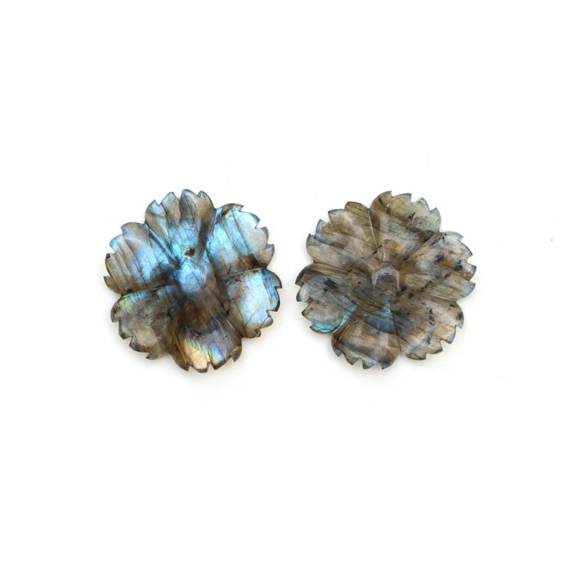 May include: Two iridescent labradorite flower-shaped cabochons with a blue and green sheen. The cabochons are carved from natural labradorite stone and have a smooth, polished finish.