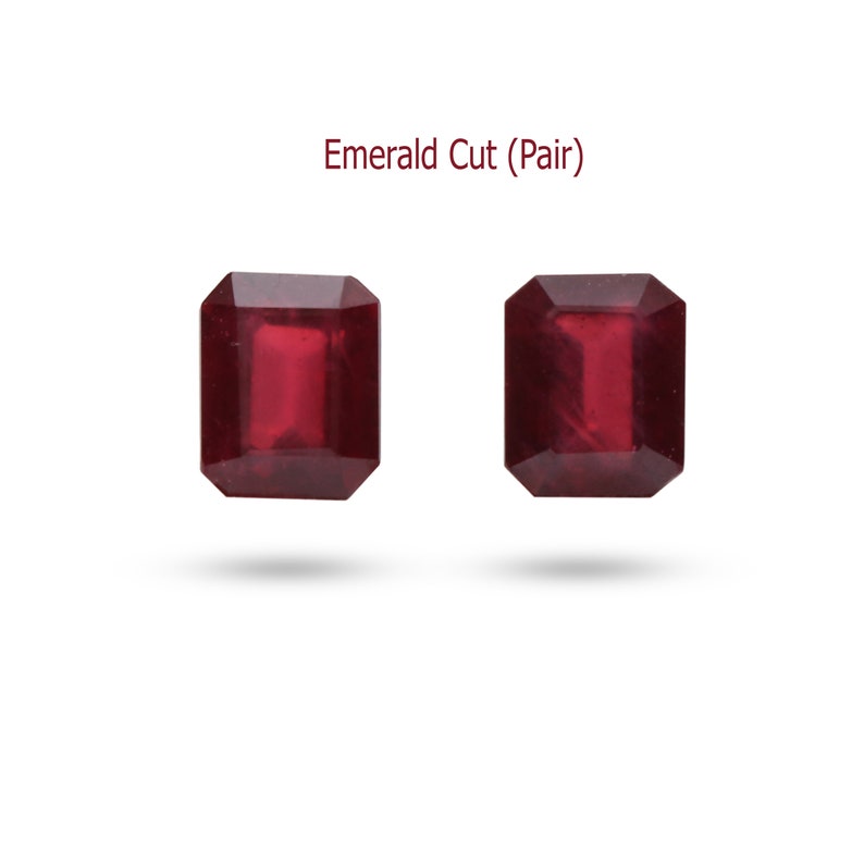 May include: A pair of deep red emerald cut gemstones. Emerald Cut (Pair)