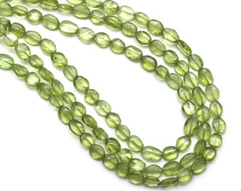 Puede incluir: Una hebra de cuentas de peridoto verde claro, de forma ovalada y facetadas, enhebradas en un hilo transparente.