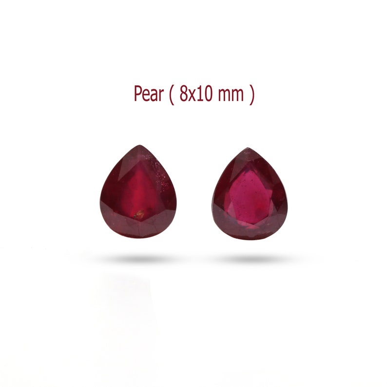 May include: Two pear-shaped red gemstones, each measuring 8x10 mm. The gemstones are faceted and have a deep red color.