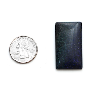 May include: A dark blue and green opal cabochon with a sparkly finish. The cabochon is about the size of a UK 20 pence coin.