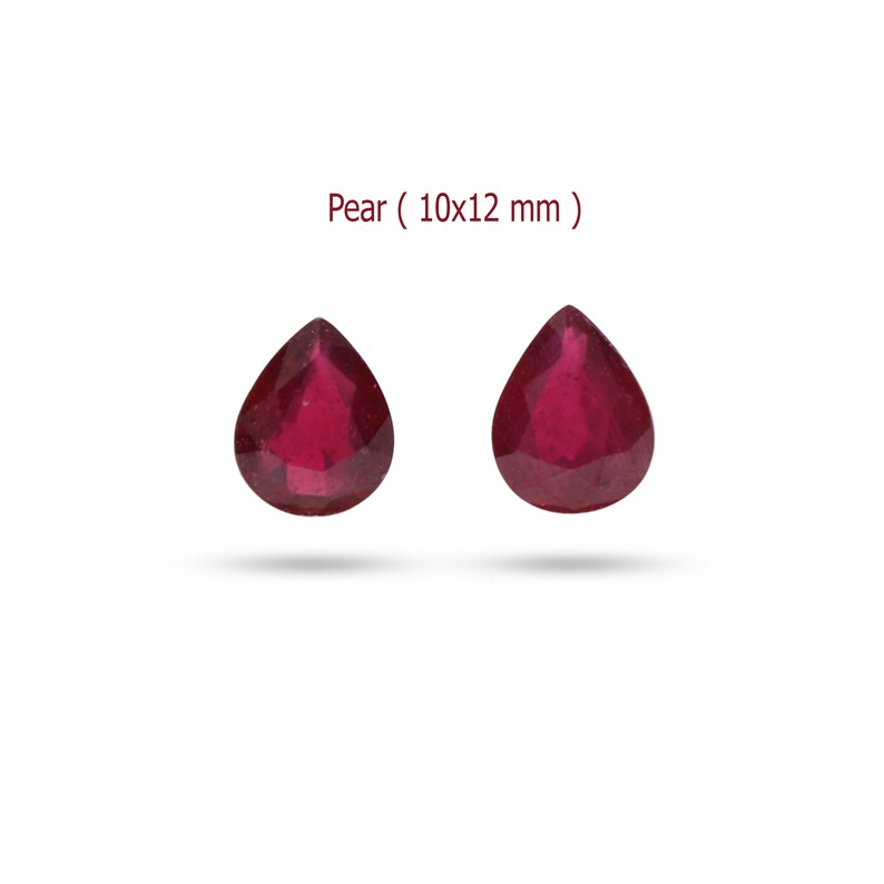 May include: Two pear-shaped red gemstones, each measuring 10x12 mm.  Pear ( 10x12 mm ) is written above the gemstones.