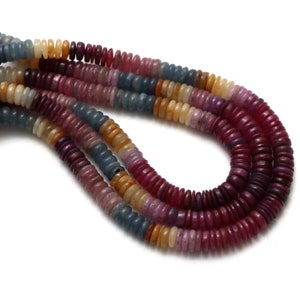 May include: A strand of colourful gemstone beads. The beads are round and flat, and they are arranged in a repeating pattern of blue, pink, red, and yellow. The beads are strung on a clear thread.