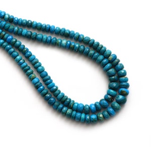 Könnte beinhalten: Eine Strähne aus türkisblauen Edelsteinperlen mit facettierter Oberfläche. Die Perlen sind auf einem durchsichtigen Faden aufgefädelt und in einem Kreis angeordnet.