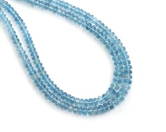May include: Three strands of light blue aquamarine gemstone beads. The beads are small, faceted, and strung together, creating a delicate necklace appearance. The background is white, highlighting the color and texture of the gemstones.