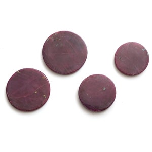 May include: Four round, purple coasters with a marbled pattern.