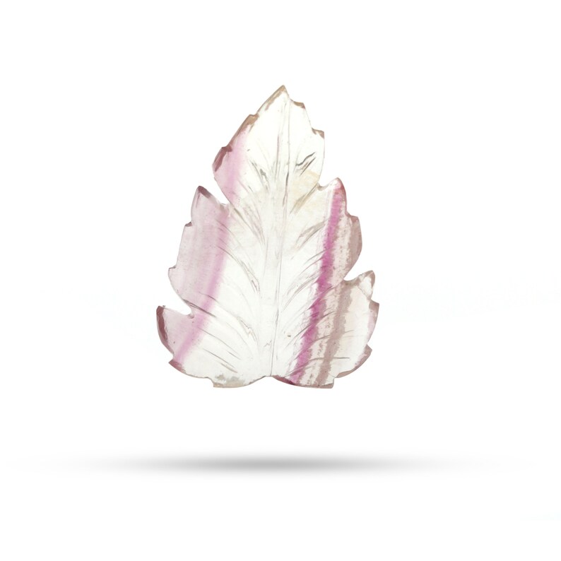 May include: A carved leaf pendant made of clear fluorite with pink and purple striations.