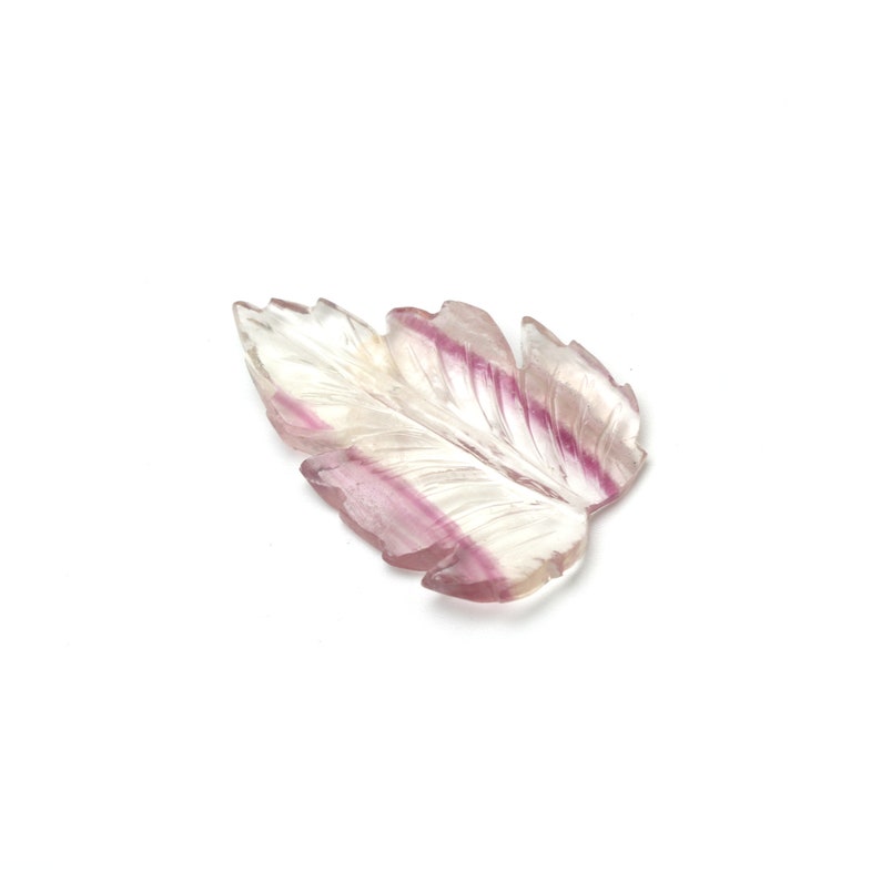 May include: A carved fluorite leaf pendant with pink and white stripes. The leaf is translucent and has a delicate, intricate design.