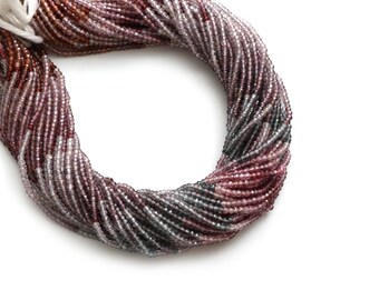 May include: A strand of faceted gemstone beads in shades of pink, purple, and gray. The beads are small and uniform in size, creating a smooth and elegant look.