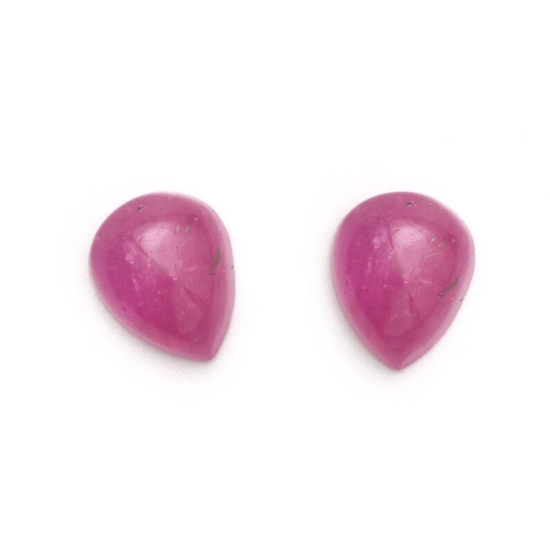 Puede incluir: Dos piedras preciosas de forma de pera rosa, cada una con una superficie lisa y pulida.