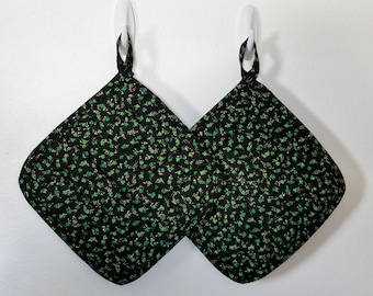 Set of 2 large quilted, handmade shamrock potholders. The potholders are glittery with small shamrocks on a black background. Nice gift