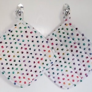 Choice of 2 large handmade and quilted potholders with paw prints and hearts, or paw prints and bones, white or pink back ground. Nice gift.