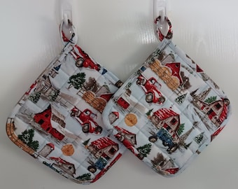Set of 2 large handmade, quilted potholders, with red farm trucks, tractors and barns on winter background. Hostess or holiday gift.