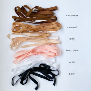 May include: Assortment of elastic bands in various colors, including cinnamon, caramel, latte, blush pink, white, and black.