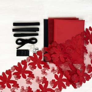 May include: Red fabric with floral lace trim, black hair ties, and a red bow. This is a craft supply kit for making hair accessories.