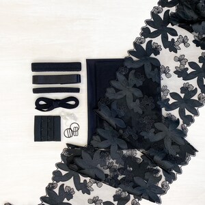 May include: Black lingerie supplies including elastic straps, a black fabric piece, black hook and eye closures, and black floral lace trim.
