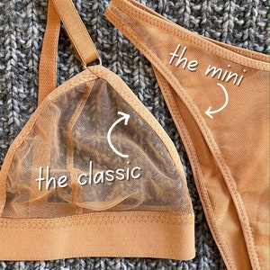 May include: Two nude-colored lingerie tops, one a classic triangle style and the other a mini style. The classic style has a mesh overlay and the mini style is a solid fabric.