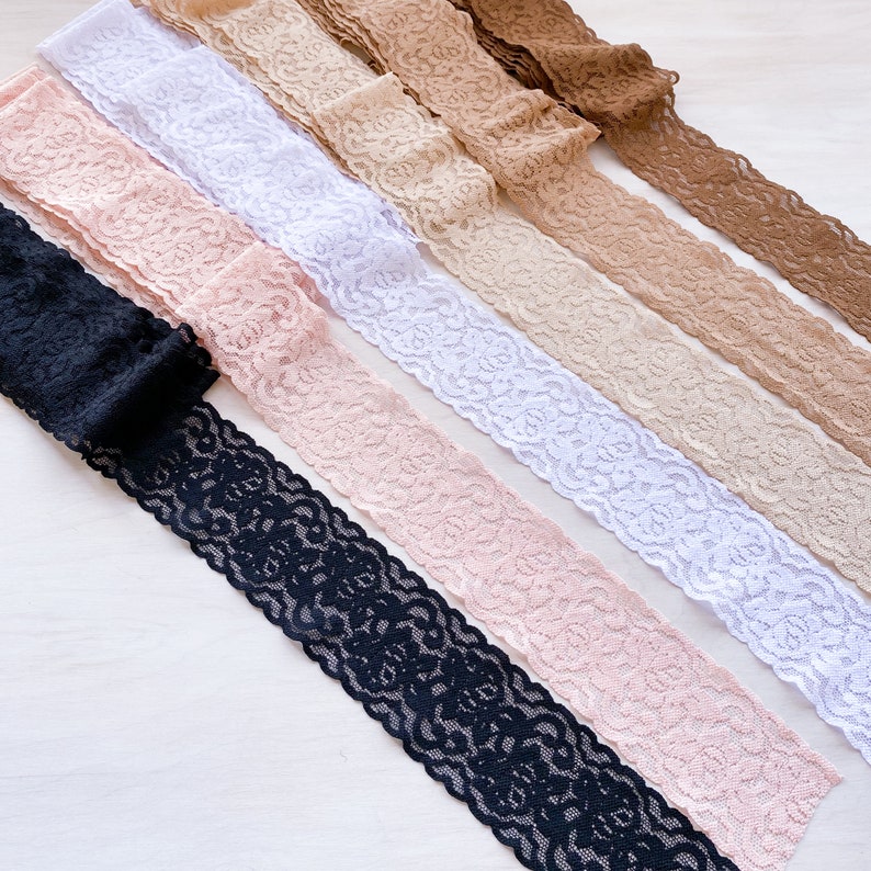 May include: Assortment of six lace trims in various colors, including black, white, beige, and pink. The lace trims have a delicate floral pattern.