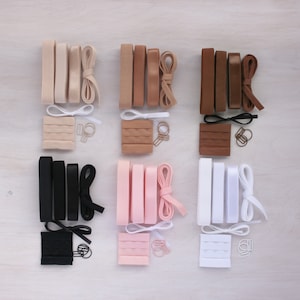 Peut inclure: Assortiment de régulateurs de bretelles de soutien-gorge de différentes couleurs, notamment noir, blanc, beige, rose et marron. Chaque ensemble comprend deux bretelles, une fermeture à crochet et à œil et un jeu de régulateurs métalliques.