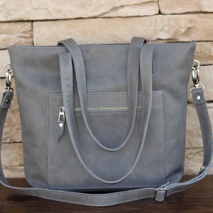 Handmade Italian leather tote with open and zipped exterior pockets, top zipper and long strap in antracite color.