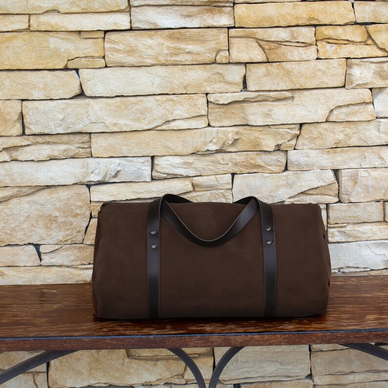 Handcrafted round travel bag in brown hue from soft true Italian leather.