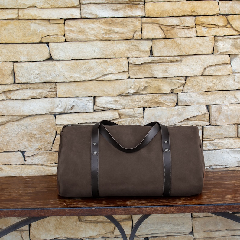 Handcrafted round travel bag in taupe hue from soft true Italian leather.