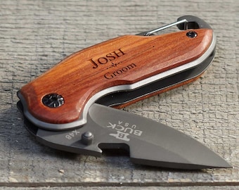 May include: Two personalized pocket knives with wooden handles. The knife on the left has the text "Mike - Groomman" engraved on the handle. The knife on the right has the text "Josh - Groom" engraved on the handle.