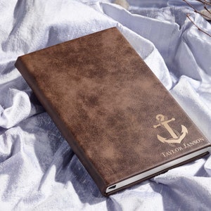 Peut inclure: Un journal en cuir marron avec une ancre dorée et le nom "Taylor Janson" gravé sur le devant.