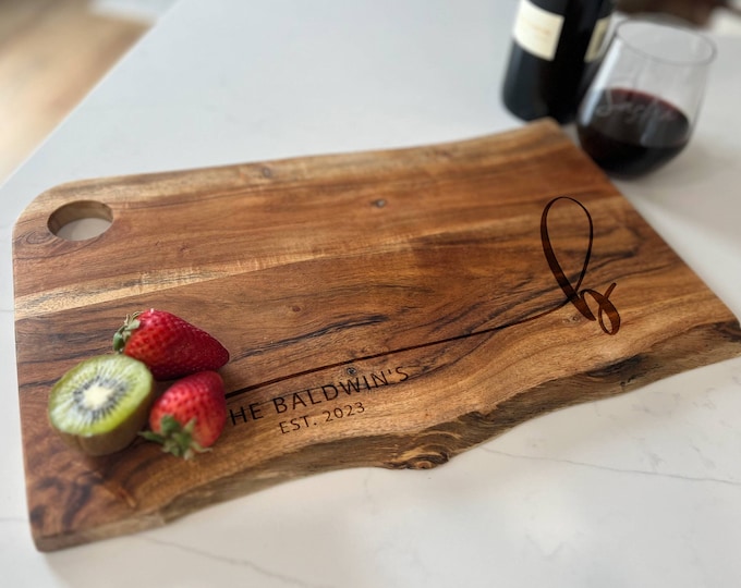 Add a personal touch to your kitchen with our laser-engraved live edge Mango wood cutting board - personalized