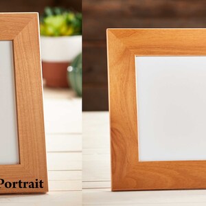 May include: Two wooden picture frames, one portrait and one landscape, with a light brown finish. The frames have a white interior and are displayed on a light-colored surface. The word "Portrait" is printed on the portrait frame, and "Landscape" is printed on the landscape frame.