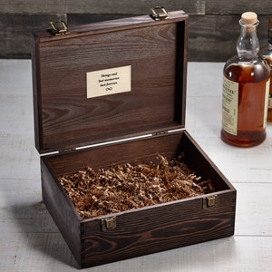 May include: A dark brown wooden box with a hinged lid and brass clasps. The box is open and filled with brown packing paper. The inscription "Things end but memories last forever" is visible on the inside of the lid.