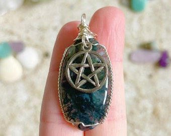 May include: A silver wire-wrapped pendant featuring a green and black agate stone with a silver pentagram charm.