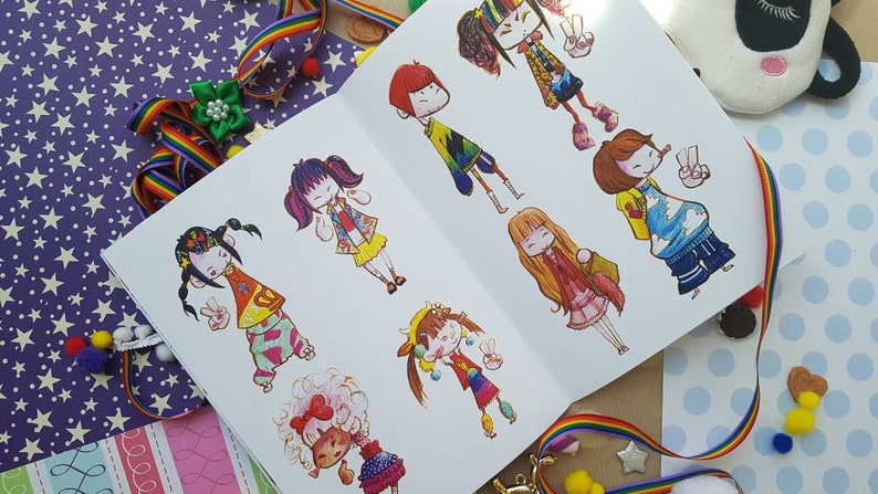 May include: A sketchbook filled with colorful illustrations of cartoon characters wearing different outfits. The characters are drawn in a whimsical style with bright colors and bold lines.