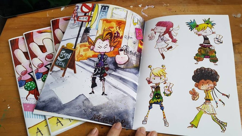 May include: An open sketchbook with colorful illustrations of cartoon characters. The characters are wearing different styles of clothing and have unique hairstyles. The sketchbook is open to a page with a character standing in front of a building with a sign that says "Today's Special".