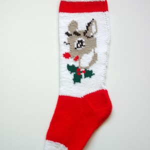 May include: White and red knitted Christmas stocking with a cartoon reindeer design. The reindeer is gray with a red nose and green holly.